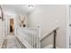 Well-lit hallway with white railing, offering access to various rooms in the home at 3130 Shadow Lake Dr, Indianapolis, IN 46217