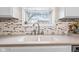 Close-up of a kitchen sink featuring tile backsplash and a bright window view at 3130 Shadow Lake Dr, Indianapolis, IN 46217