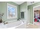 Spa-like bathroom with a soaking tub, natural light and calming green walls at 3130 Shadow Lake Dr, Indianapolis, IN 46217