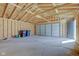 Spacious unfinished garage interior with new framing, garage door, and side entrance at 334 N 15Th Ave, Beech Grove, IN 46107