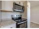 This close-up features a new stainless steel microwave and oven with a smooth cooktop at 334 N 15Th Ave, Beech Grove, IN 46107