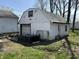 Detached white garage exhibiting visible wear, with a partially open door at 3751 Creston Dr, Indianapolis, IN 46222