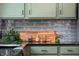 Stylish kitchen with sage-colored cabinetry, granite countertops, and a grey tile backsplash at 3764 E Glenwood Dr, Martinsville, IN 46151