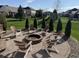 Beautiful backyard with stone fire pit, Adirondack chairs, and manicured landscaping at 3789 Shady Pointe Row, Greenwood, IN 46143