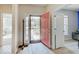 Inviting entryway with a brightly colored front door, light wood floors, and views into a bedroom and living area at 3789 Shady Pointe Row, Greenwood, IN 46143