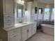 Elegant bathroom with custom white cabinetry, a sleek countertop, and a modern free-standing tub in a bright space at 415 N Westview Dr, Columbus, IN 47201