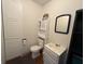 Cozy bathroom featuring a toilet, sink, storage cabinet and a mirror with blue trim at 415 N Westview Dr, Columbus, IN 47201