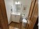 Bathroom featuring vanity, toilet, and hardwood floors, wood door at 415 N Westview Dr, Columbus, IN 47201
