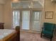 Bright bedroom boasts three patio doors with blinds, a decorative chair, and a calming color palette at 415 N Westview Dr, Columbus, IN 47201