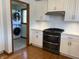 Modern kitchen with stainless steel appliances, white cabinets, and laundry room access at 415 N Westview Dr, Columbus, IN 47201