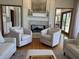 Cozy living space featuring a stone fireplace with white mantle, hardwood floors, and plush seating at 415 N Westview Dr, Columbus, IN 47201