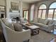 Bright living room with a stone fireplace, neutral furniture, and large arched windows offering natural light at 415 N Westview Dr, Columbus, IN 47201