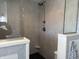 Stylish walk-in shower featuring sleek gray tiling, a shower bench, and a rainfall shower head at 415 N Westview Dr, Columbus, IN 47201