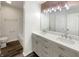 Well-lit bathroom with double vanity, modern fixtures, and wood look flooring at 4630 Kelvington Dr, Indianapolis, IN 46254