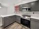 Modern kitchen with stainless steel appliances, gray cabinets, and a stylish tile backsplash at 4630 Kelvington Dr, Indianapolis, IN 46254