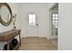 Bright entryway with a console table, round mirror and wood-look floors at 5181 Golden Grove Dr, McCordsville, IN 46055