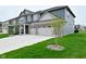 Charming two-story home boasts a three-car garage and well-manicured lawn at 5181 Golden Grove Dr, McCordsville, IN 46055