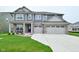 Charming two-story home boasts a three-car garage and well-manicured lawn at 5181 Golden Grove Dr, McCordsville, IN 46055