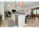 Open concept kitchen with island featuring white cabinets, stainless steel dishwasher and modern pendant lighting at 5181 Golden Grove Dr, McCordsville, IN 46055