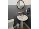 Powder room with grey walls, pedestal sink, round mirror and modern fixtures at 5181 Golden Grove Dr, McCordsville, IN 46055