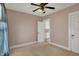 Neutral-toned bedroom with ceiling fan and view into the kitchen at 52 N Oakland Ave, Indianapolis, IN 46201