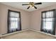 A bright bedroom with two windows, ceiling fan, neutral carpet, and baseboard trim at 52 N Oakland Ave, Indianapolis, IN 46201