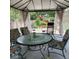 Comfortable gazebo with a glass-top table and cushioned chairs, perfect for outdoor dining and relaxation at 52 N Oakland Ave, Indianapolis, IN 46201