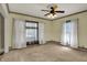 Spacious living room features two large windows, neutral carpeting, and a classic ceiling fan at 52 N Oakland Ave, Indianapolis, IN 46201