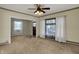 Bright living room with neutral carpet, two large windows, and a ceiling fan at 52 N Oakland Ave, Indianapolis, IN 46201