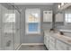 Bathroom with a double sink vanity, storage cabinets, and a glass shower enclosure at 5223 Jerry Ct, Indianapolis, IN 46254