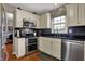 Modern kitchen featuring stainless steel appliances, black countertops, and white cabinetry at 5223 Jerry Ct, Indianapolis, IN 46254