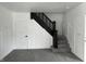 Newly carpeted staircase features modern railing and classic paneling that adds visual interest and style at 608 N Gray St, Indianapolis, IN 46201