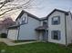 Angle view of a two-story home with a two-car garage, blue shutters, and a manicured lawn at 6120 Salanie Pl, Indianapolis, IN 46254