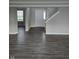 Bright living room features dark hardwood floors, neutral walls, and entry to the staircase at 6120 Salanie Pl, Indianapolis, IN 46254