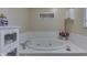 Bathroom featuring a white bathtub, decorative cabinets, and tile walls at 6599 Meadowlark Dr, Nineveh, IN 46164