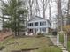 Charming two-story light blue lake house with a well-maintained lawn and a wooden walkway and staircases at 6599 Meadowlark Dr, Nineveh, IN 46164