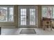 Bright sun room featuring white double doors, tile floors, and views of the lake at 6599 Meadowlark Dr, Nineveh, IN 46164