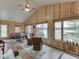 Bright sunroom boasts vaulted ceilings, wood paneling, water views and inviting seating at 6599 Meadowlark Dr, Nineveh, IN 46164