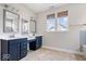 Bathroom featuring a double vanity with blue cabinets, two mirrors and natural light at 7012 Pickett Pl, Carmel, IN 46033