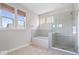 Well-lit bathroom with bathtub, glass-enclosed shower, and neutral tile at 7012 Pickett Pl, Carmel, IN 46033