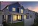Exterior view of a home's backyard with a covered patio and privacy fence at dusk at 7012 Pickett Pl, Carmel, IN 46033