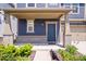 Inviting front porch with brick accents, a stylish blue front door, and lush landscaping at 7012 Pickett Pl, Carmel, IN 46033