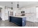 Modern kitchen with white cabinets, stainless steel appliances, and a dark blue kitchen island at 7012 Pickett Pl, Carmel, IN 46033