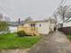 Backyard with a deck, sliding glass doors, grass, and stone landscaping at 709 S A St, Elwood, IN 46036