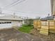 View of a one car garage, deck, grass, and stone landscaping in the backyard at 709 S A St, Elwood, IN 46036