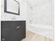 Stylish bathroom with a dark vanity, modern faucet, and a bathtub with elegant tile surround at 709 S A St, Elwood, IN 46036