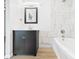 Well-lit bathroom featuring a dark vanity, large mirror, and a bathtub with stylish tile surround at 709 S A St, Elwood, IN 46036