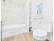 Bright bathroom featuring new shower, tub with tile surround, and built-in shelving for convenient storage at 709 S A St, Elwood, IN 46036