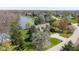 Aerial view of a home featuring mature trees, landscaping, circular drive and water views at 7371 Windridge Way, Brownsburg, IN 46112