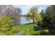 Stunning backyard with mature trees, a tranquil lake, and lush green landscape at 7371 Windridge Way, Brownsburg, IN 46112